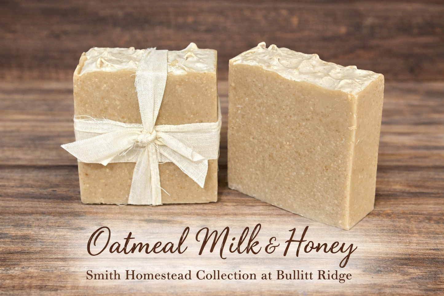 Two bars of oatmeal milk and honey soap on a wooden surface with 'Smith Homestead Collection at Bullitt Ridge' text. The bar on the left is wrapped in a cloth ribbon that accentuates a vintage vibe.